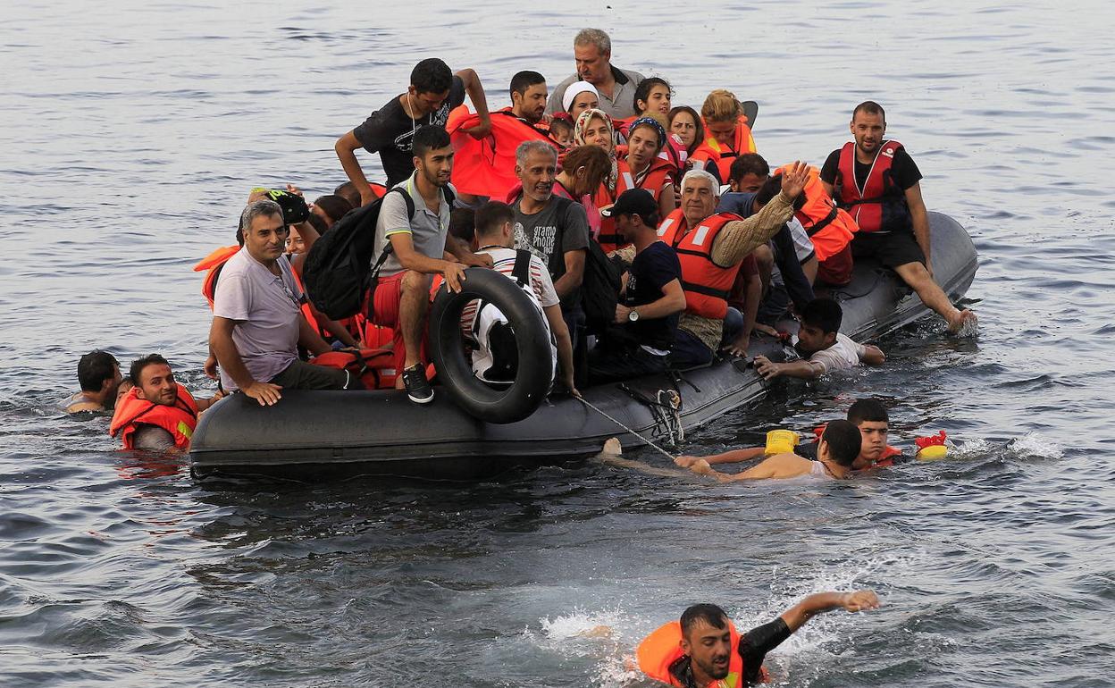 Varios refugiados sirios llegan en una lancha neumática a la costa de Mitilene en la isla de Lesbos, Grecia.