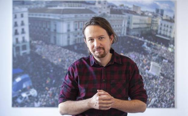 Pablo Iglesias posa junto a la foto del mitin de Podemos en 2015 en la Puerta del Sol.