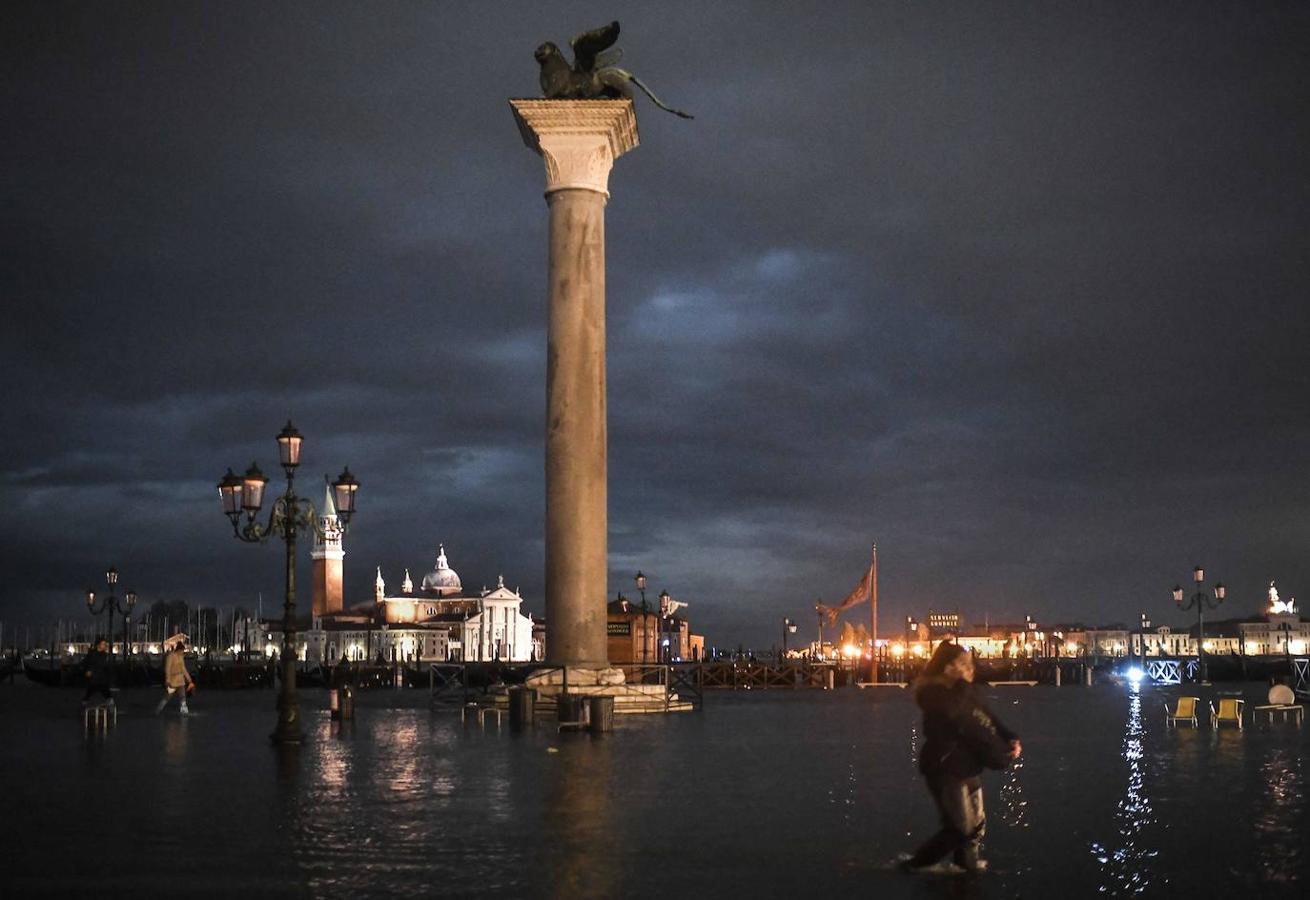 Una vista general muestra el Palacio Ducal (i) con vistas a la Plaza de San Marcos inundada, la estatua de bronce alada del León de San Marcos, las góndolas y la laguna veneciana.