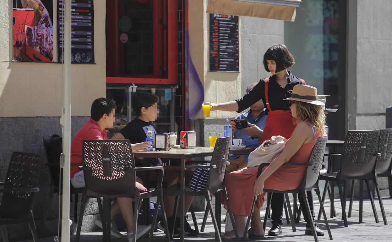 Una camarera atiende la terraza de un restaurante en Madrid.