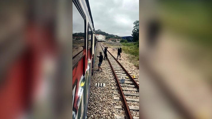 Imágenes de los detenidos realizando un grafiti en un tren. 