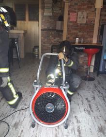 Imagen secundaria 2 - Imágenes de los bomberos en el interior del bar. 