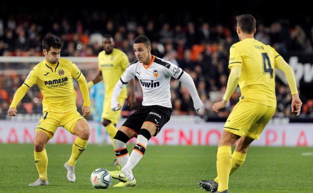 Rodrigo, jugador del Valencia, rodeado de defensas del Villarreal 