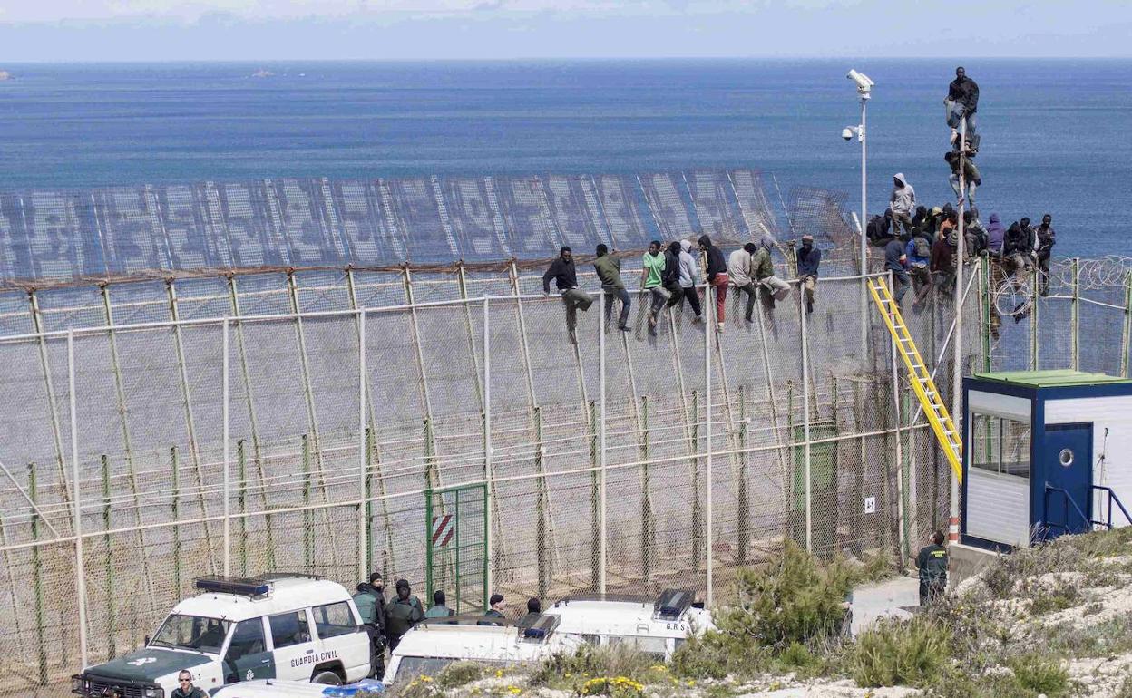 Varios inmigrantes intentan salvar la valla de Melilla. 