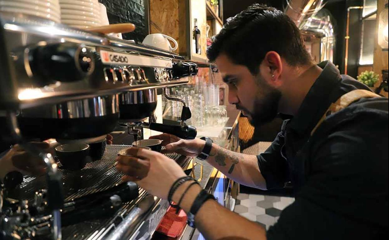 Miguel Páez prepara dos cafés en su establecimiento hostelero.