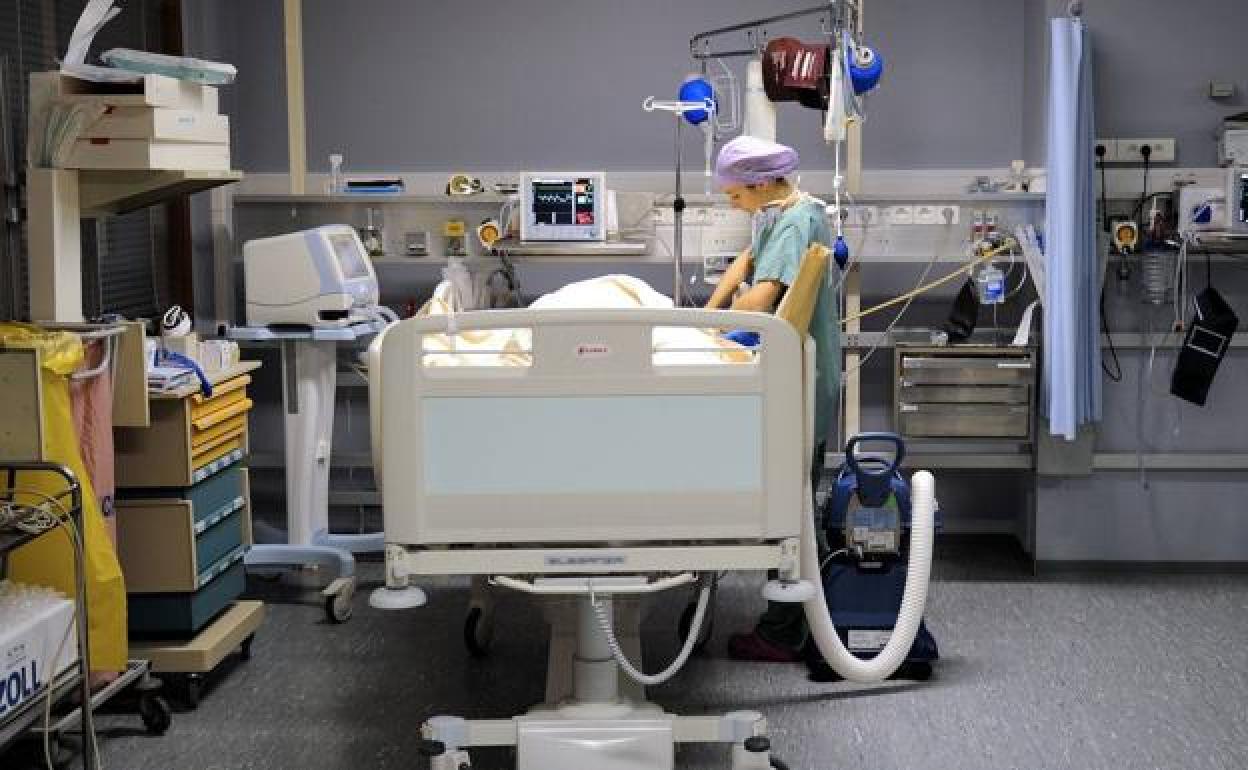 Una enfermera cuida de un paciente en una sala de recuperación. / 