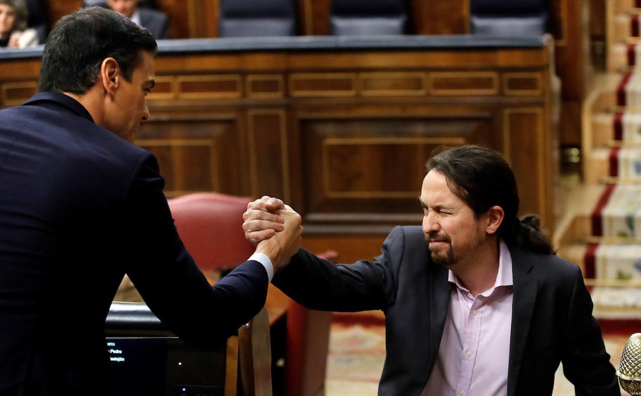 Pedro Sánchez y Pablo Iglesias se estrechan la mano en el Congreso.