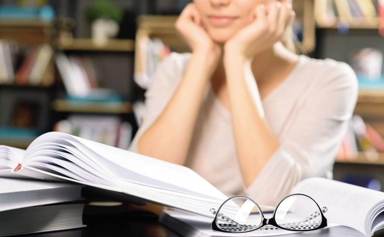 Una joven estudiando en su casa sin medios electrónicos.