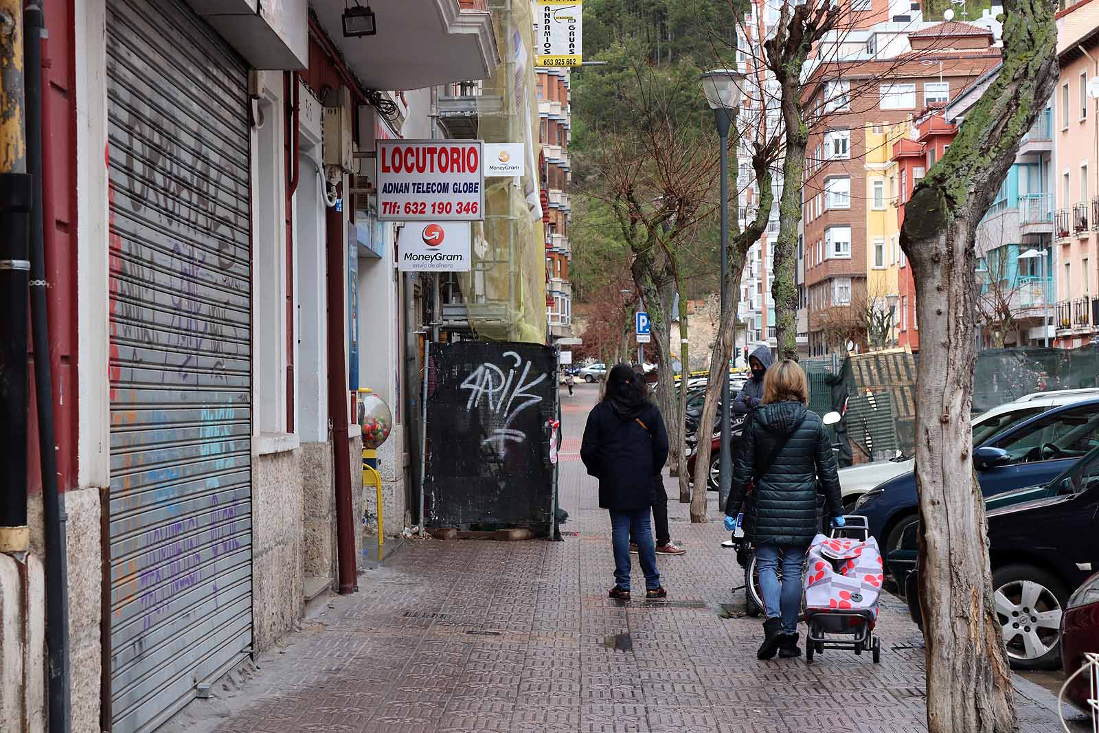 Una vecina consulta una esquela en la calle.