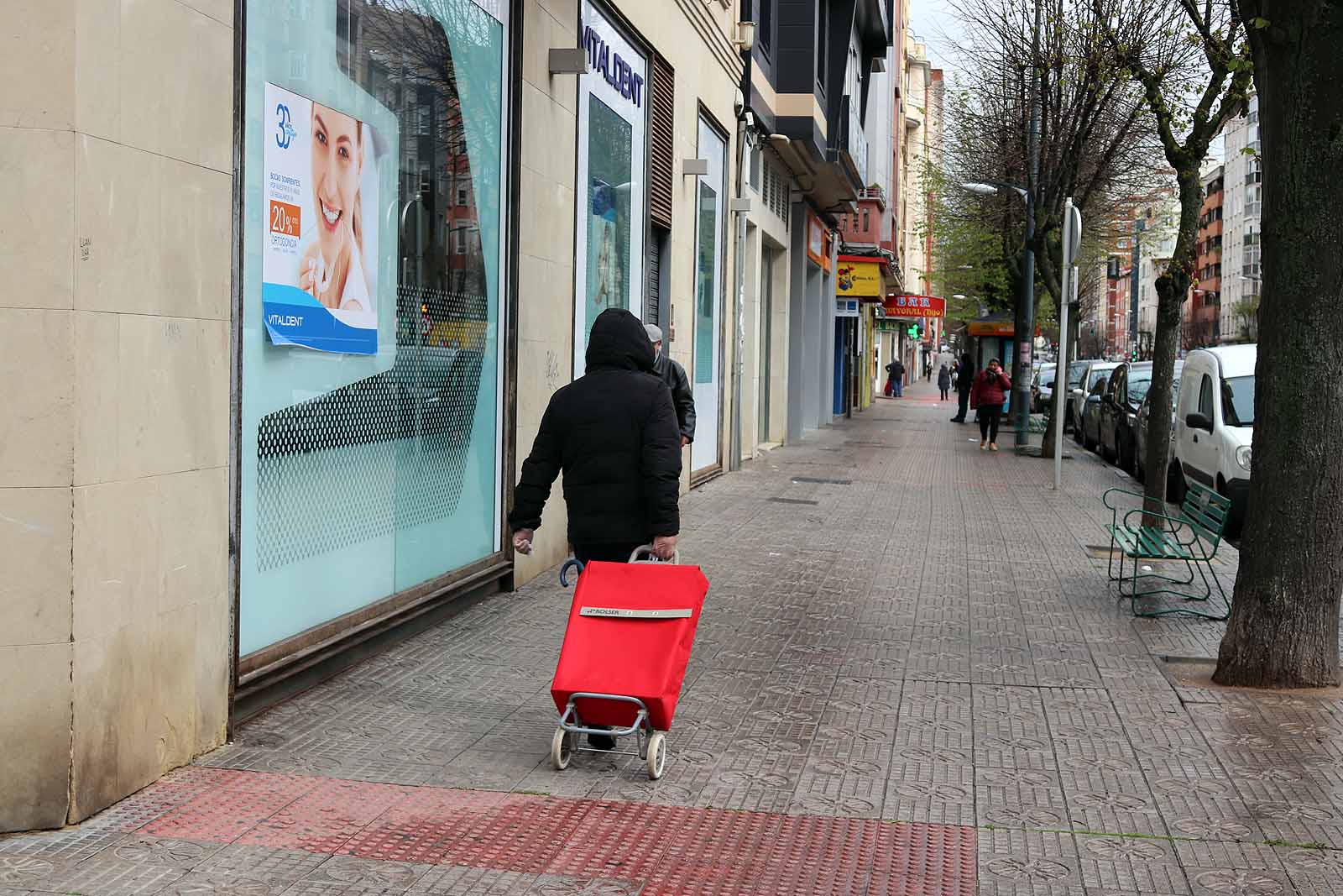 Una vecina consulta una esquela en la calle.