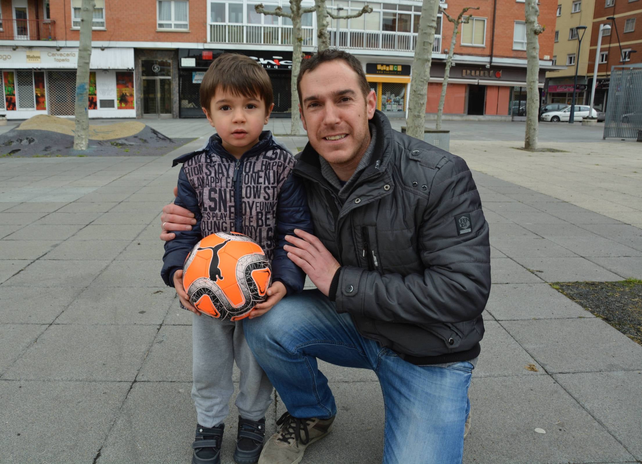 Un niño corre con su padre en Aranda de Duero. 