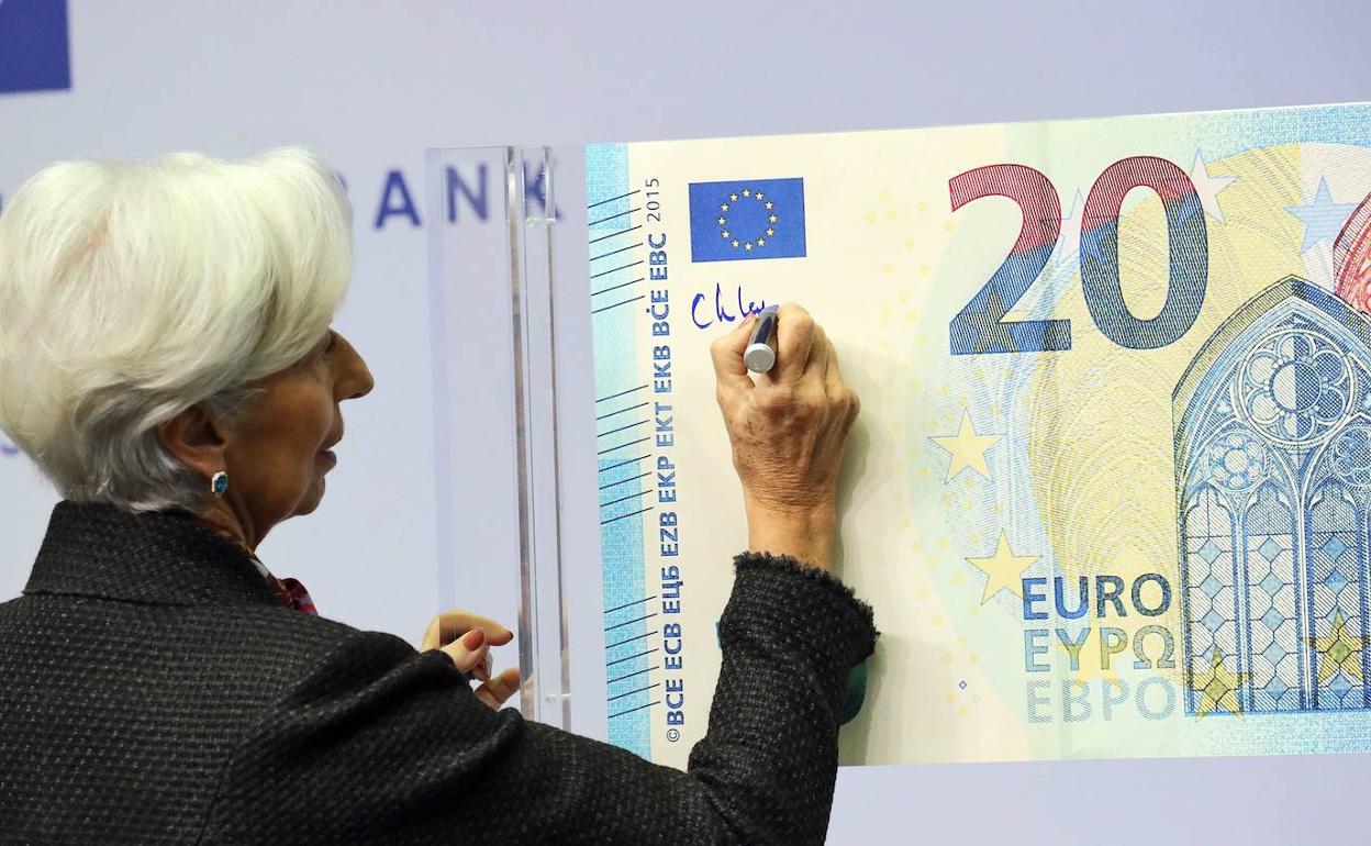 Christine Lagarde, presidenta del Banco Central Europeo firma un billete de 20 euros.