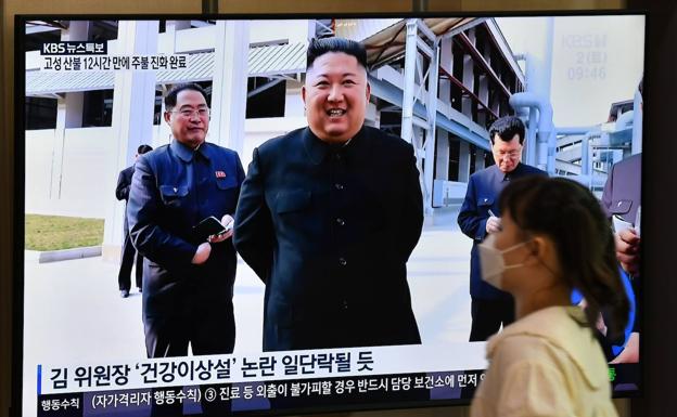 Una Mujer ve la telvisión en la que sale Kim Jong Um. 