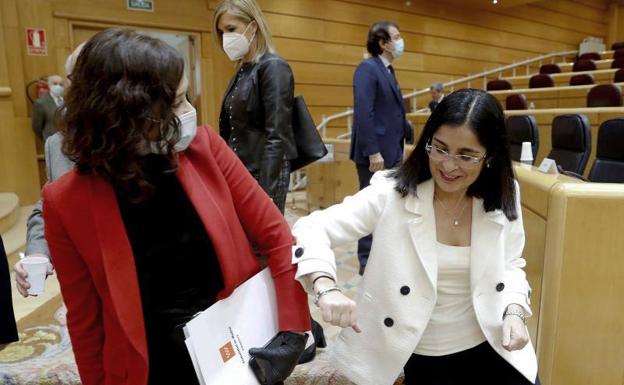 La ministra Carolina Darias saluda con el codo a la presidenta de Madrid, Isabel Díaz Ayuso, en el Senado.