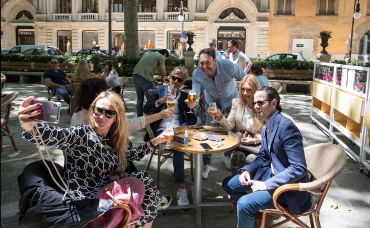 Varias personas posan para una fotografía en una terraza de Palma de Mallorca.