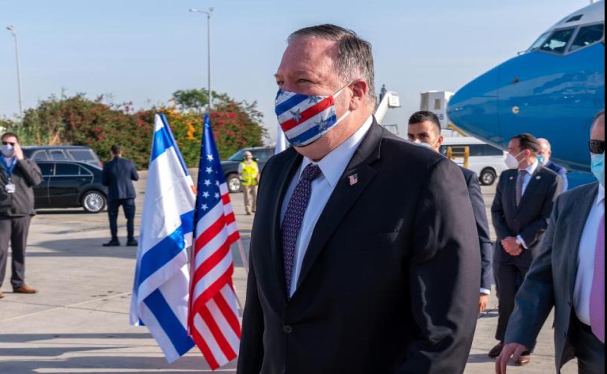 Pompeo baja de su avión en el aeropuerto de Tel Aviv cubierto con una mascarilla con barras y estrellas.