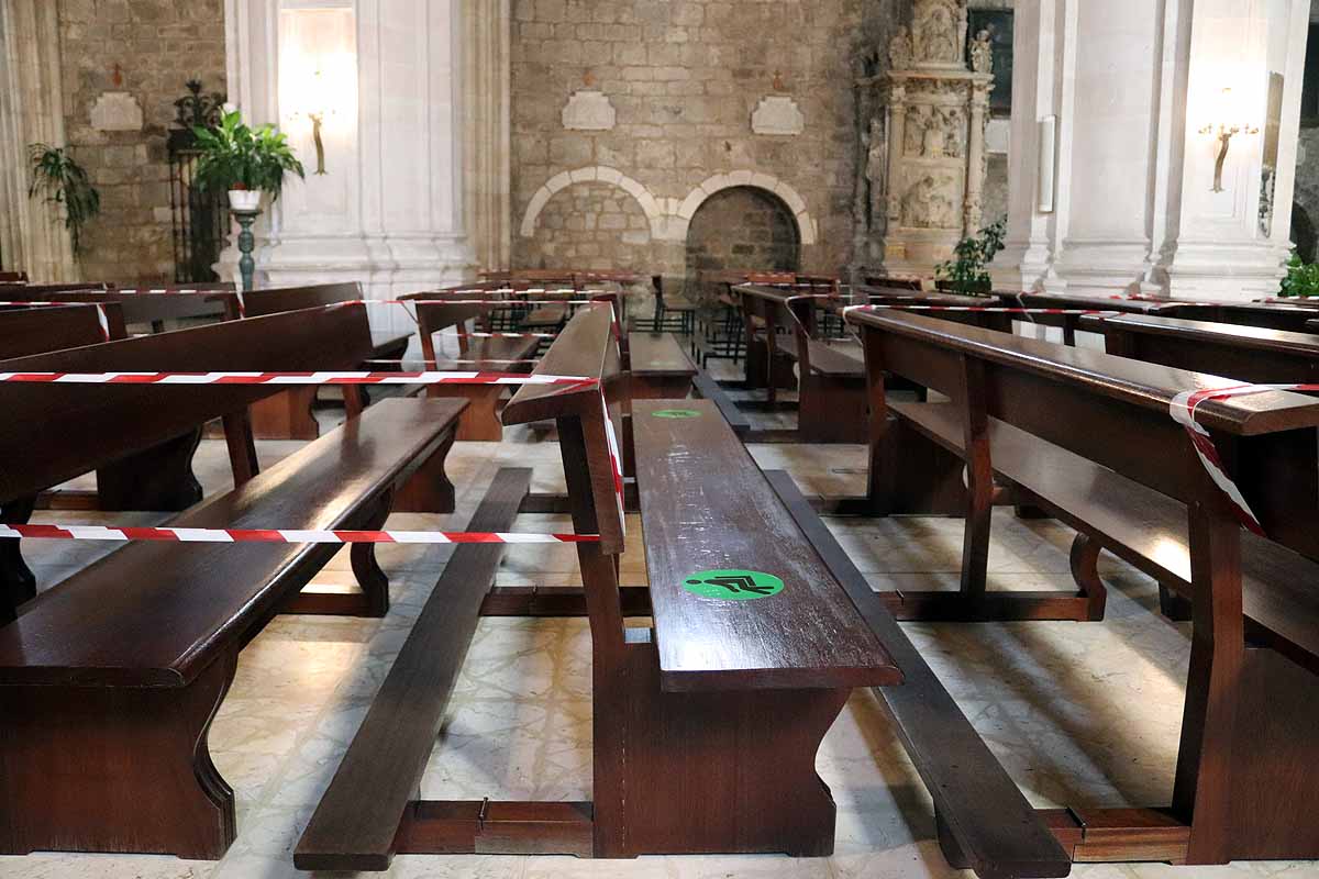 Una mujer se echa gel desinfectante a la entrada de la iglesia deSan Lesmes en Burgos. 