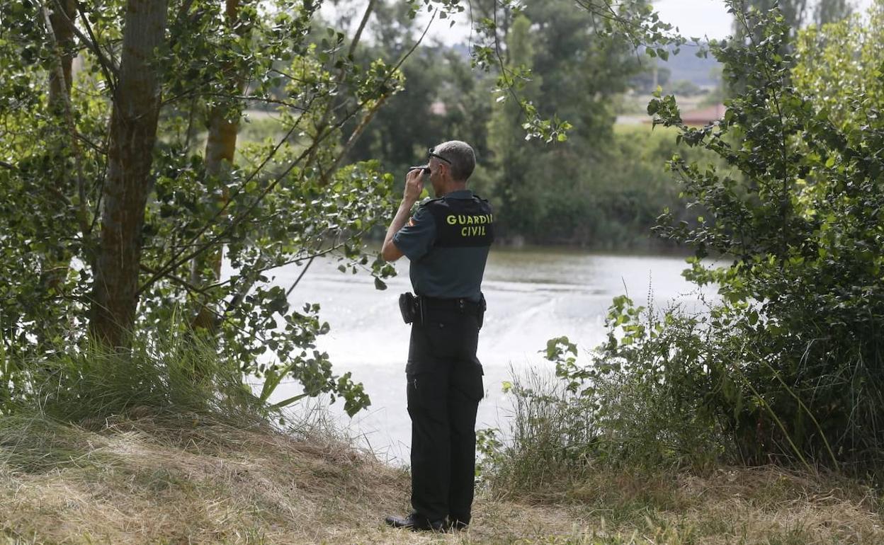 Un agente de la Guardia Civil otea con sus prismáticos la confluencia del Duero y el Pisuerga durante la tarde del sábado.