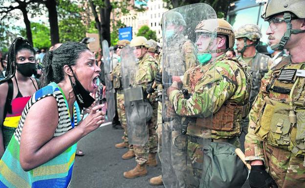 Imagen principal - Una manifestante ante la Casa Blanca en Washington se encara con los militares colocados ante la protesta. | Manifestante con una mascarilla con las últimas palabras de Floyd: 'No puedo respirar'. | El policía Derek Chauvin mantuvo inmovilizado así a George Floyd durante más de ocho minutos, hasta que murió.