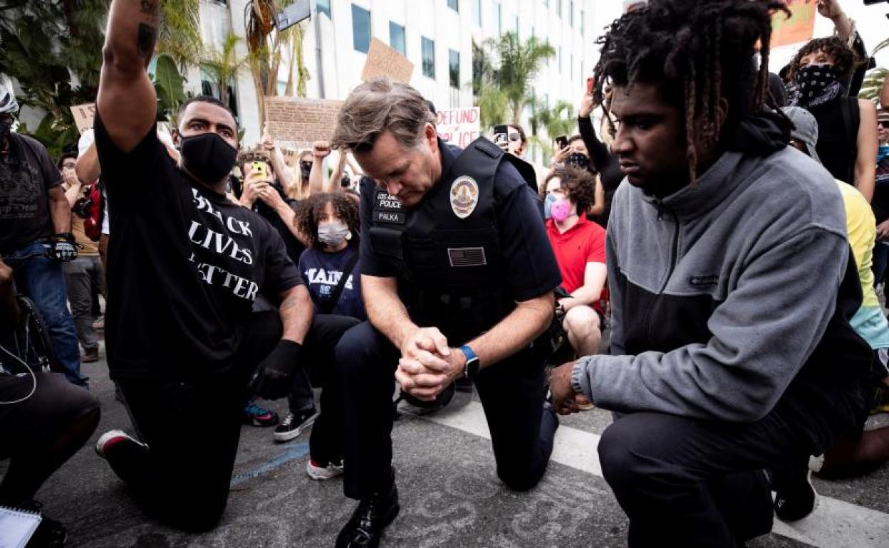 El comandante de la Policía de Los Ángeles Cory Palka (c) se arrodilla en Los Angeles 