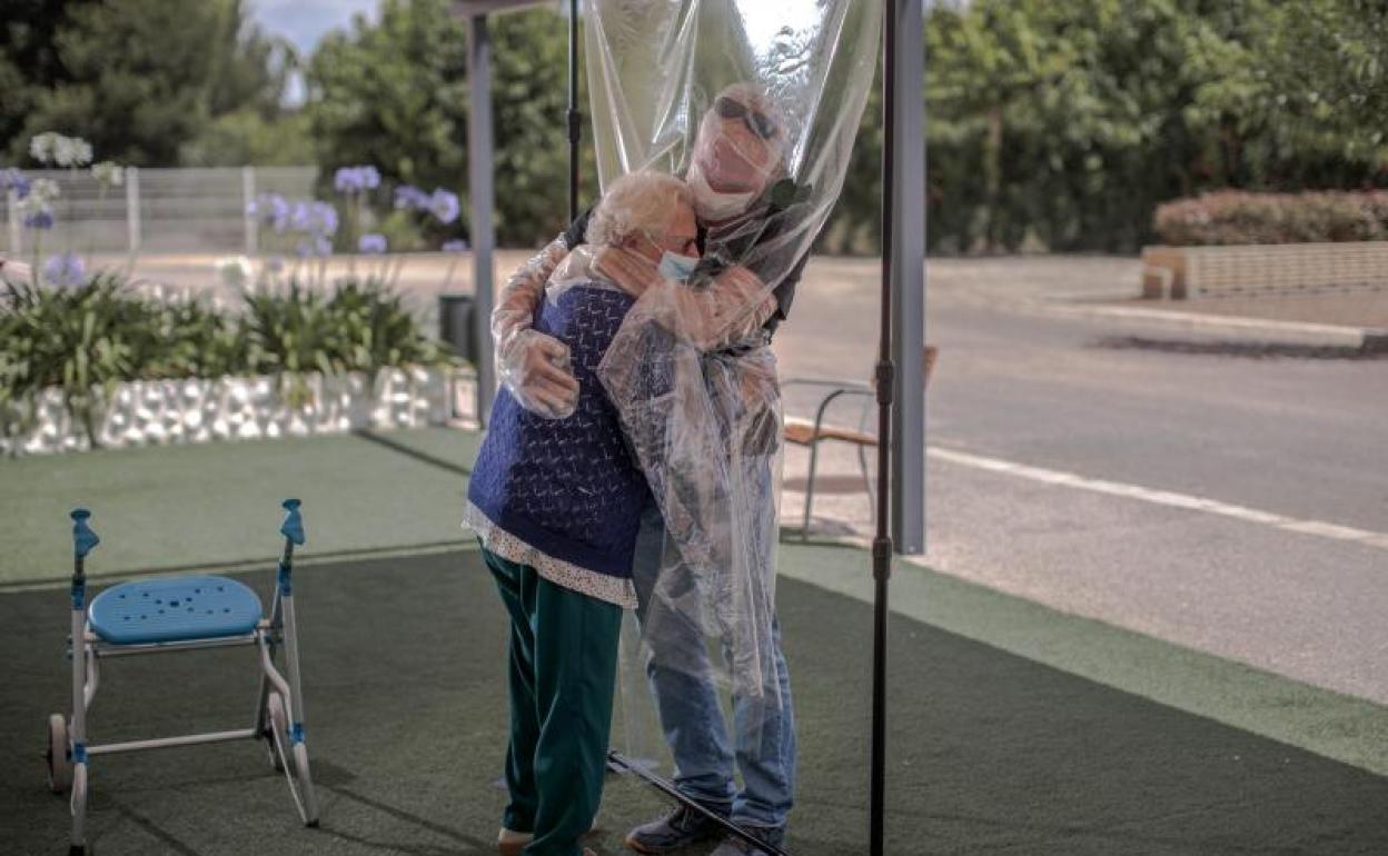 Una interna en una residencia de mayores abraza a su hijo a través de un plástico habilitado para que los familiares se puedan dar su primer abrazo desde hace tres meses, debido al estado de alarma decretado por la pandemia del coronavirus. 