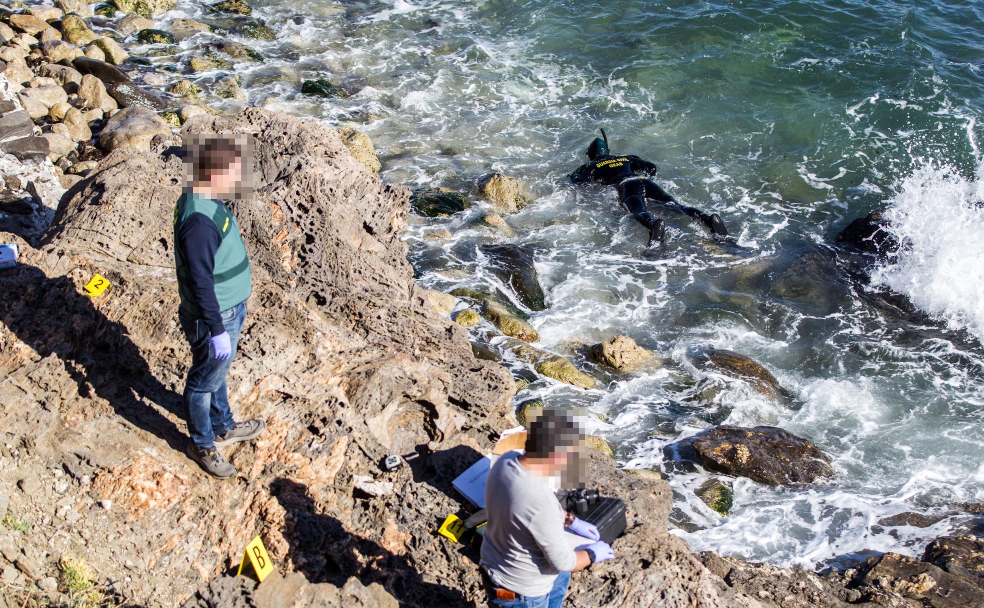 Policías buscan pruebas en la playa de Mijas, donde en diciembre pasado apareció un cadáver con más de cuarenta impactos de bala. 