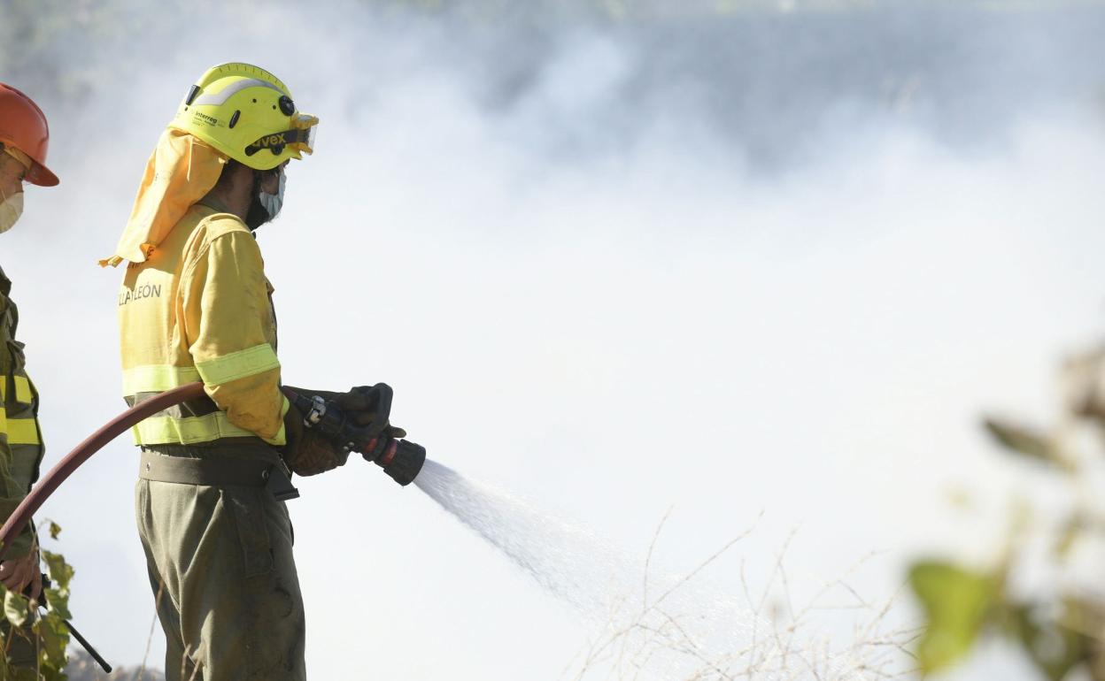 Un bomberos actuando sobre un incendio. 