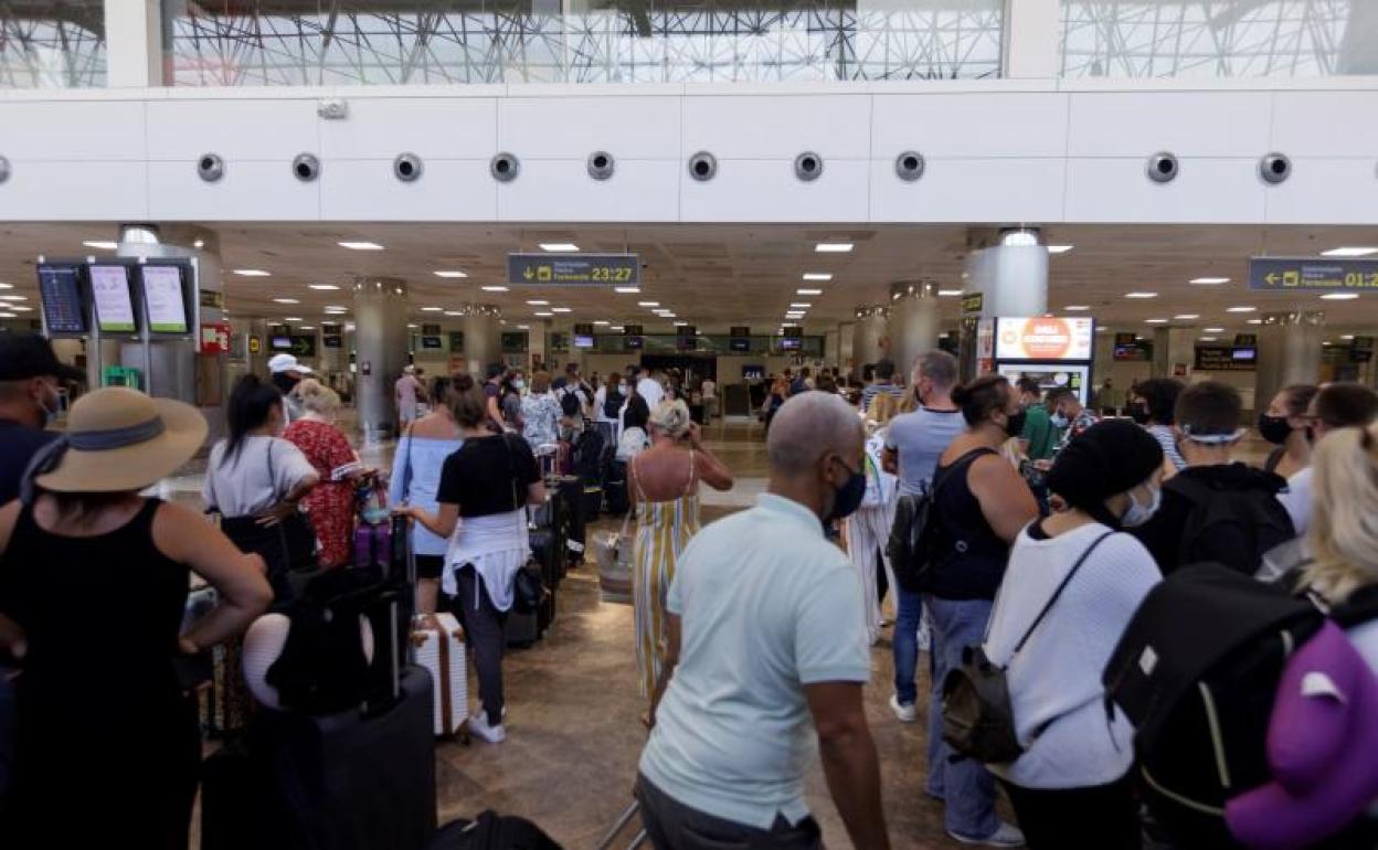 Viajeros con destino al Reino Unido hacen cola para facturar en el aeropuerto de Tenerife Sur 