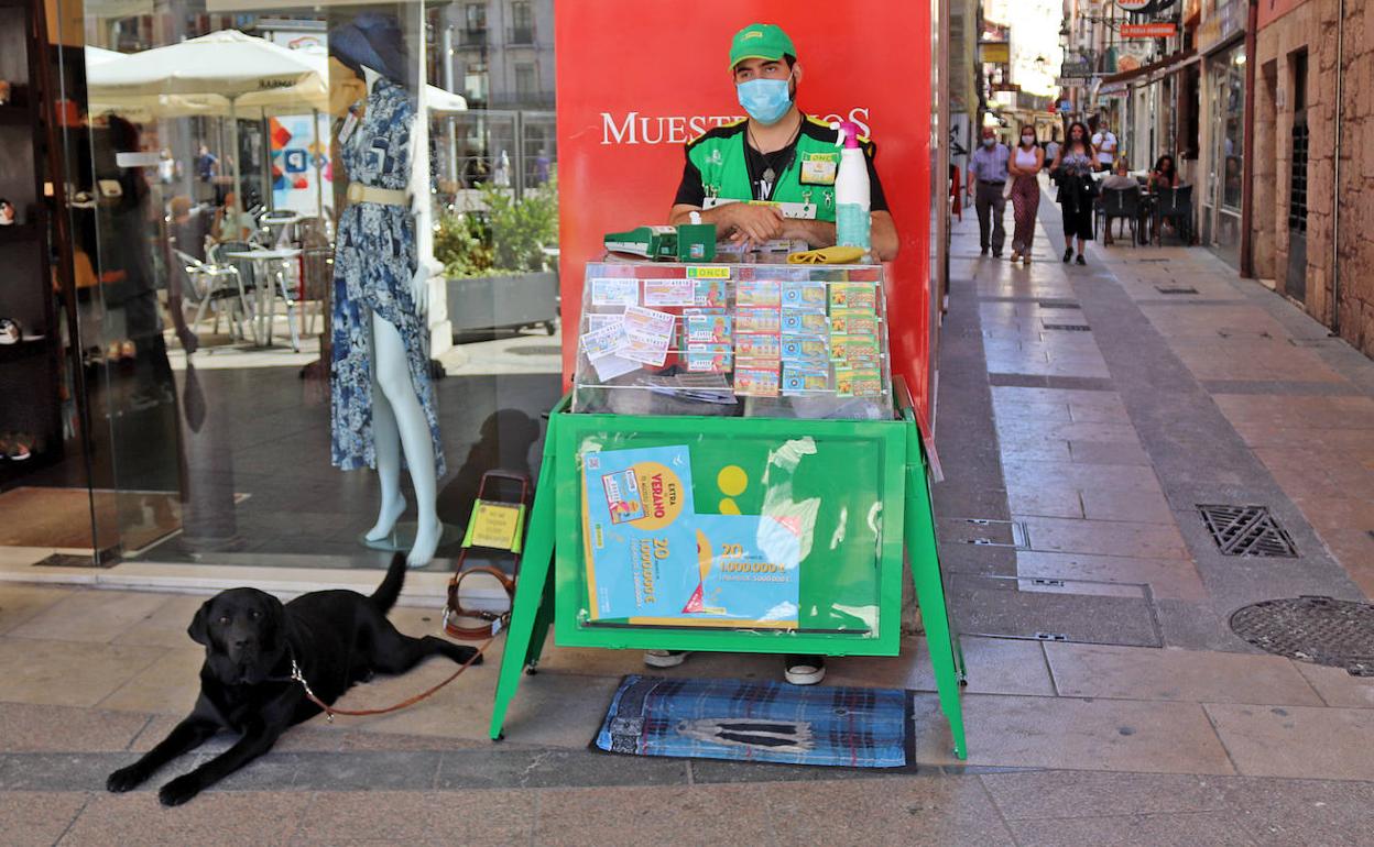 Rubén y su perro guía, Korky, en el mostrador de la ONCE de la Plaza Mayor donde vende cupones desde hace un año y ocho meses. 