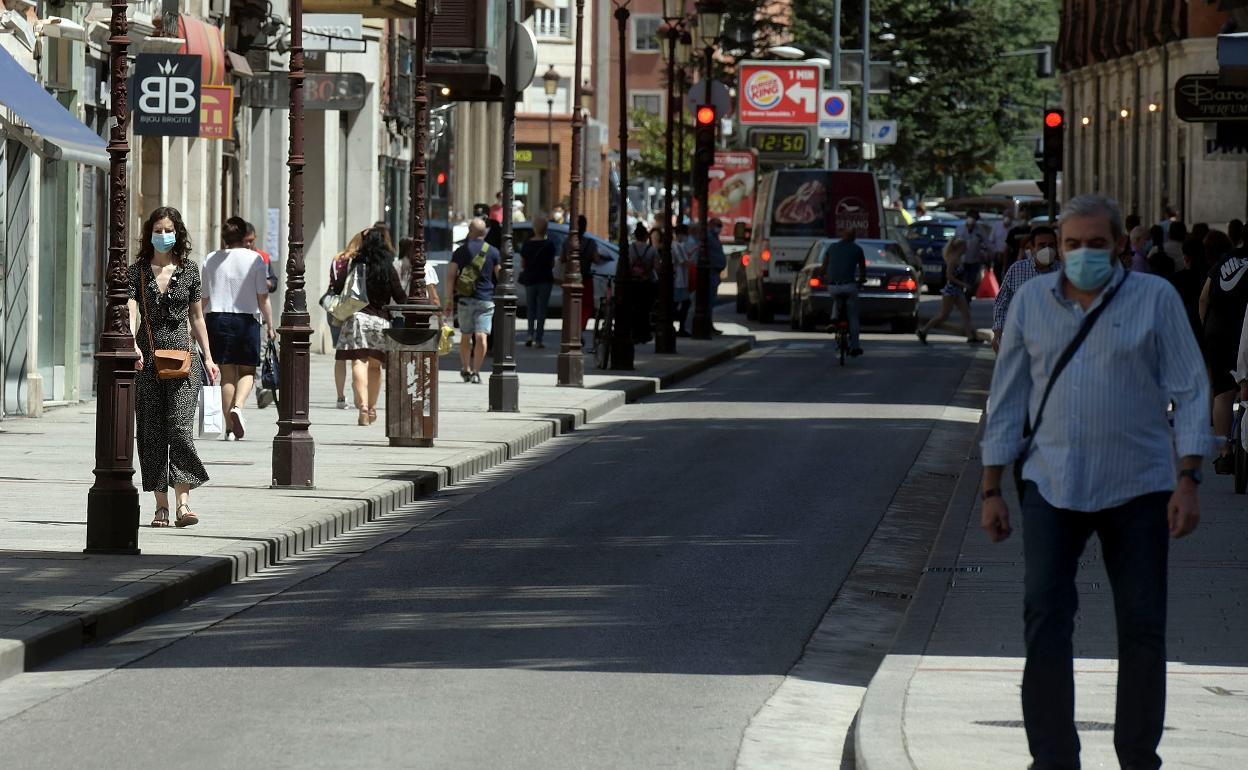 Imagen de una calle de Burgos con personas con mascarillas impuestas por la covid-19. 