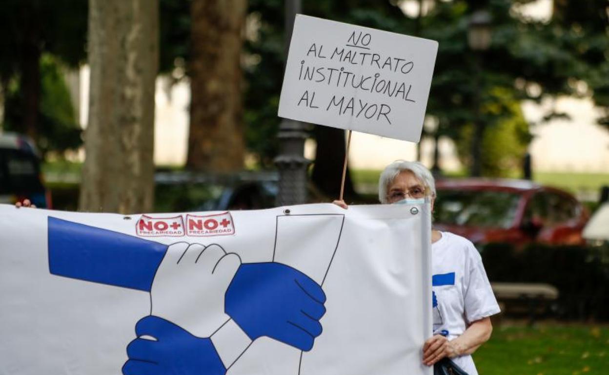 Una mujer sostiene un cartel en el que se lee 'No al maltrato institucional al mayor' durante una concentración convocada por Marea de Residencias.