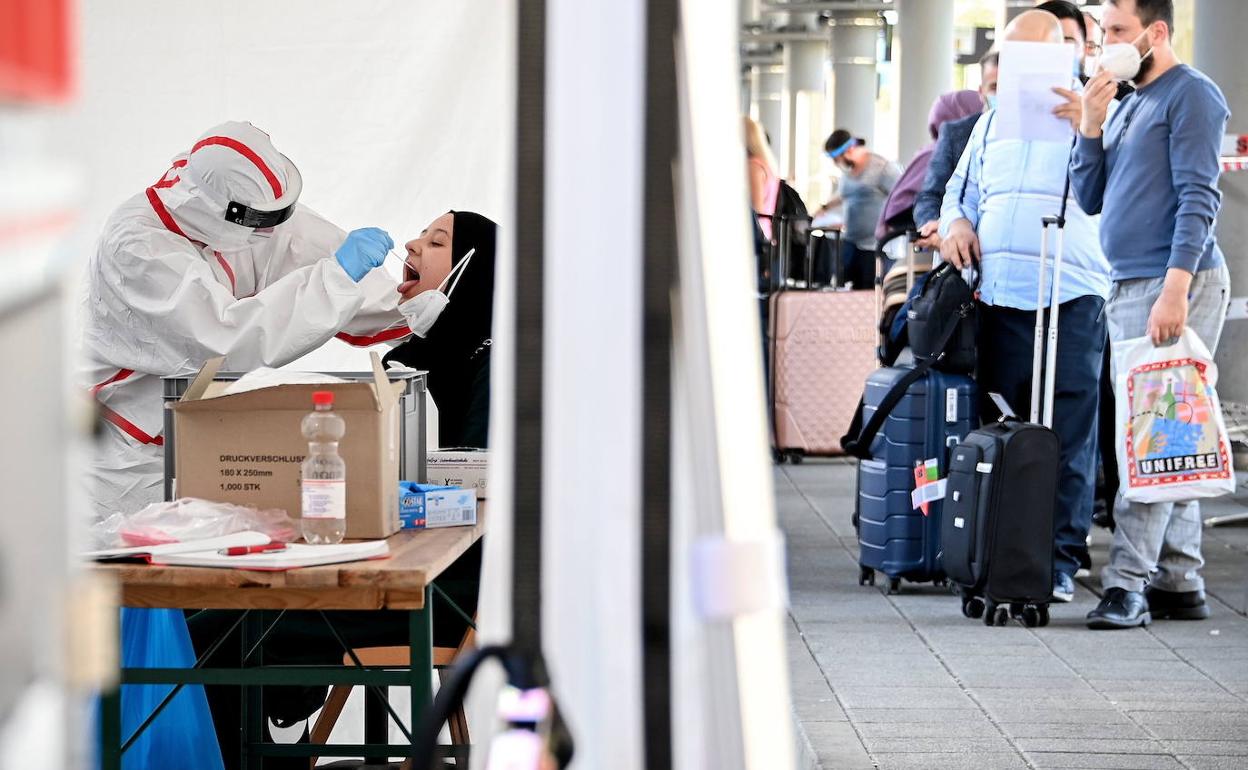 Viajeros se someten a pruebas para detectar o descartar la infección por la covid-19 a su llegada al aeropuerto de Colonia.