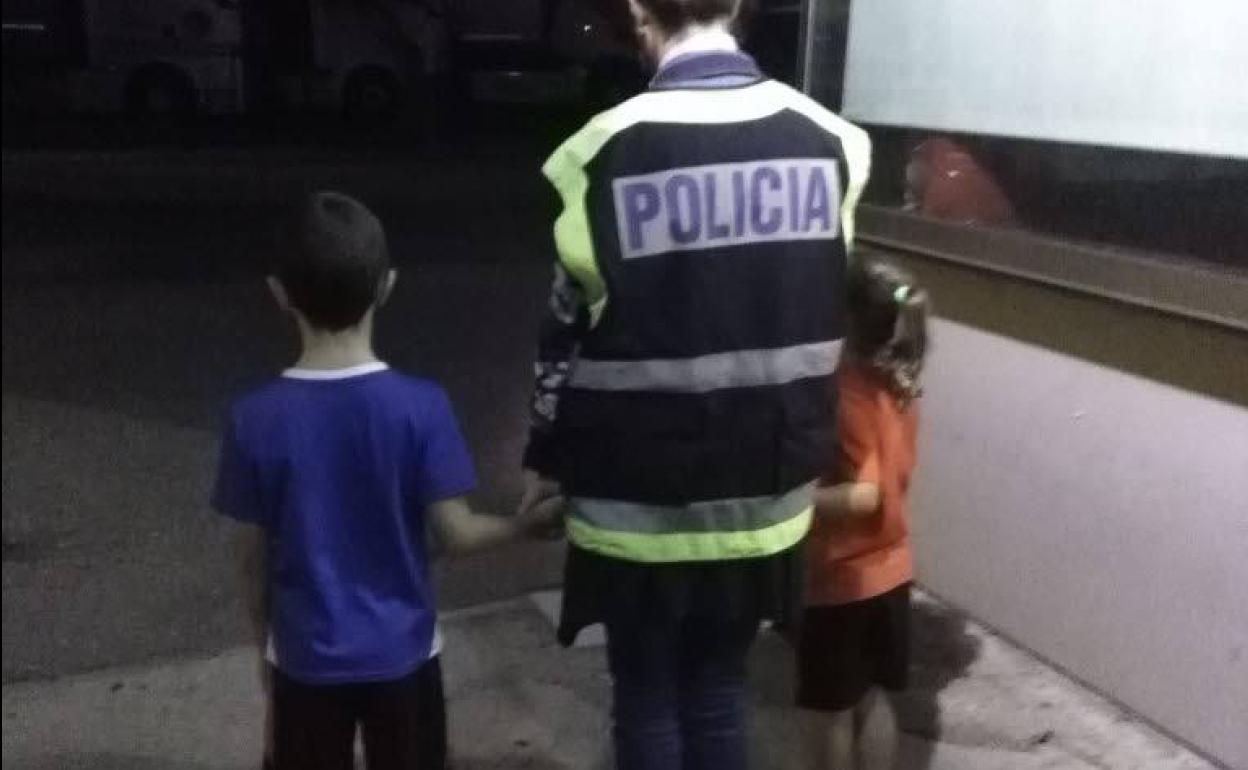 Imagen de archivo de una policía con dos menores. 