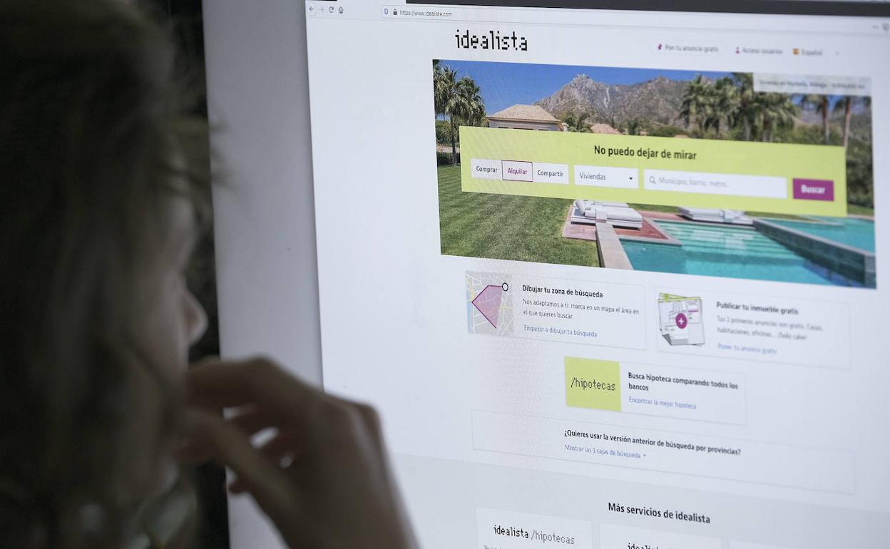 Una mujer ante la página web de idealista.com 