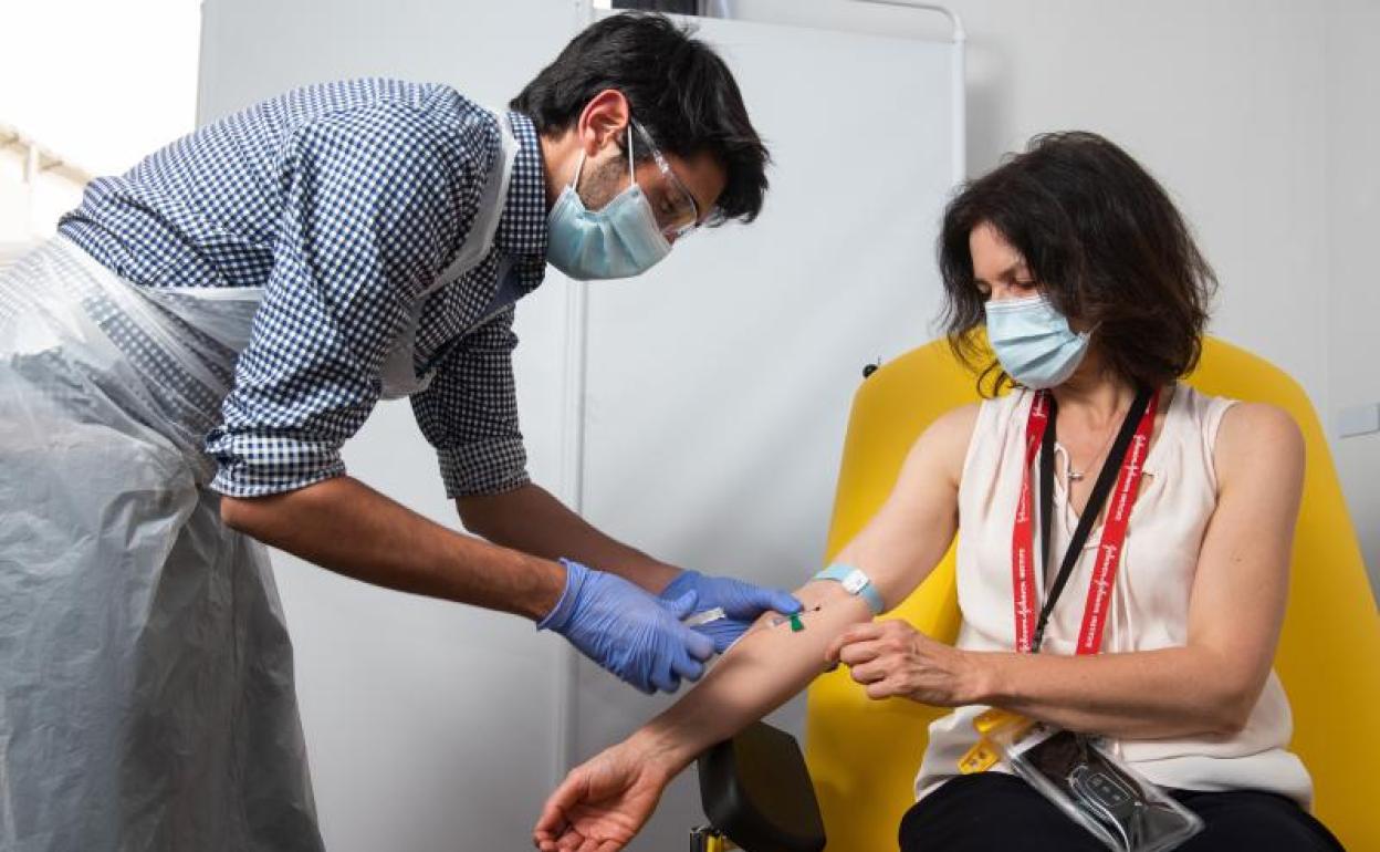 Un sanitario administra la vacuna a una voluntaria 