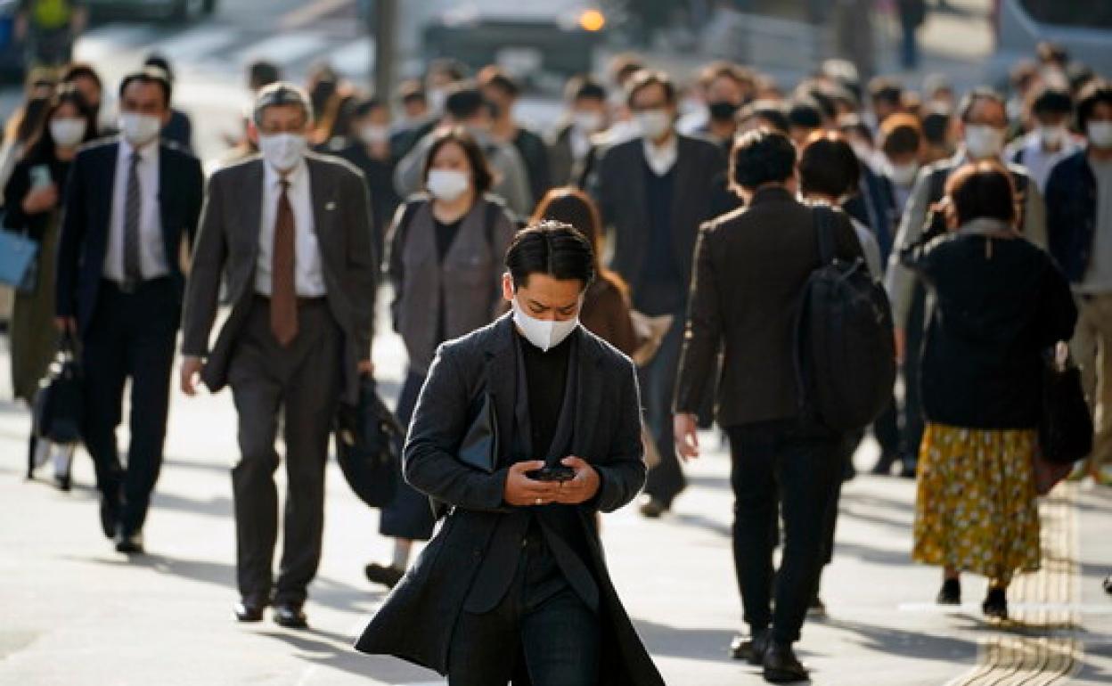 Personas caminan con mascarillas en Tokio (Japón) 