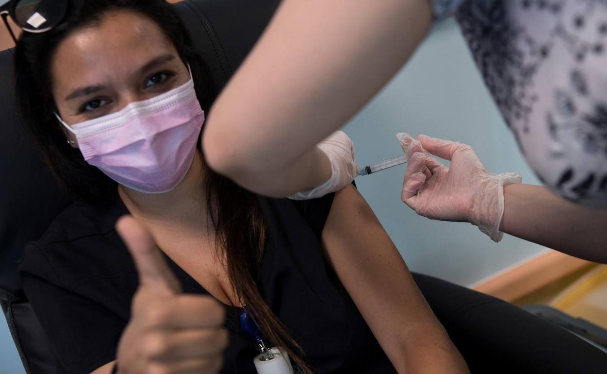 Una joven en Chile poniéndose una vacuna contra la covid, cuya campaña comenzó este jueves