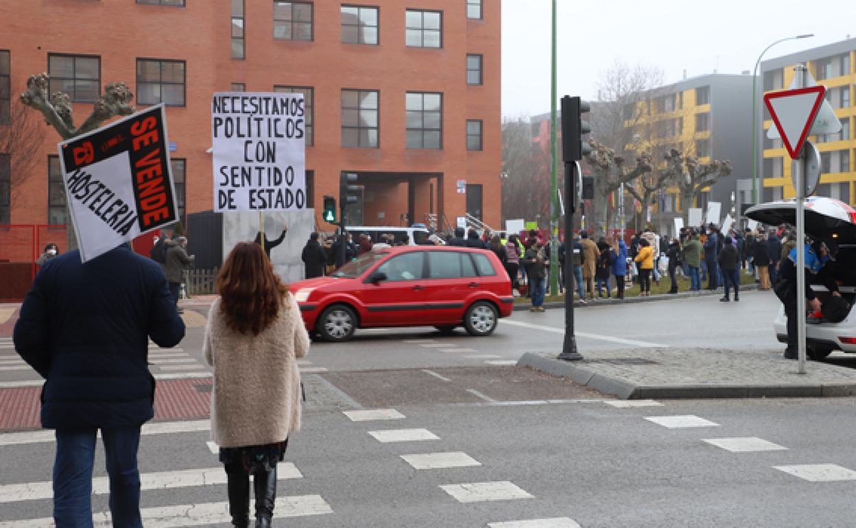 Dos personas acuden a la protesta de la hostelería, en la delegación de la Junta en Burgos. 