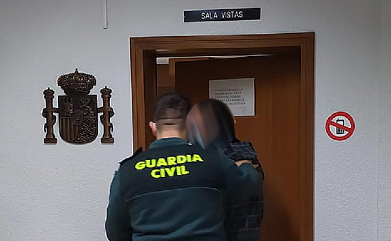 Un agente acompaña al detenido a la Sala de Vistas. 