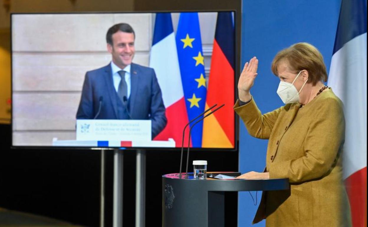 Merkel y Macron se saludan al término de la reunión de este viernes.