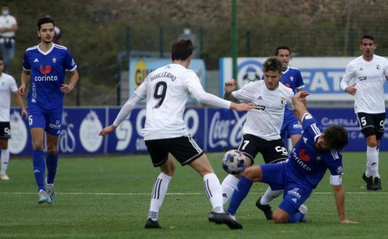 Juanma y Guillermo luchan por un balón con un rival del Covadonga, en el encuentro de la primera vuelta.