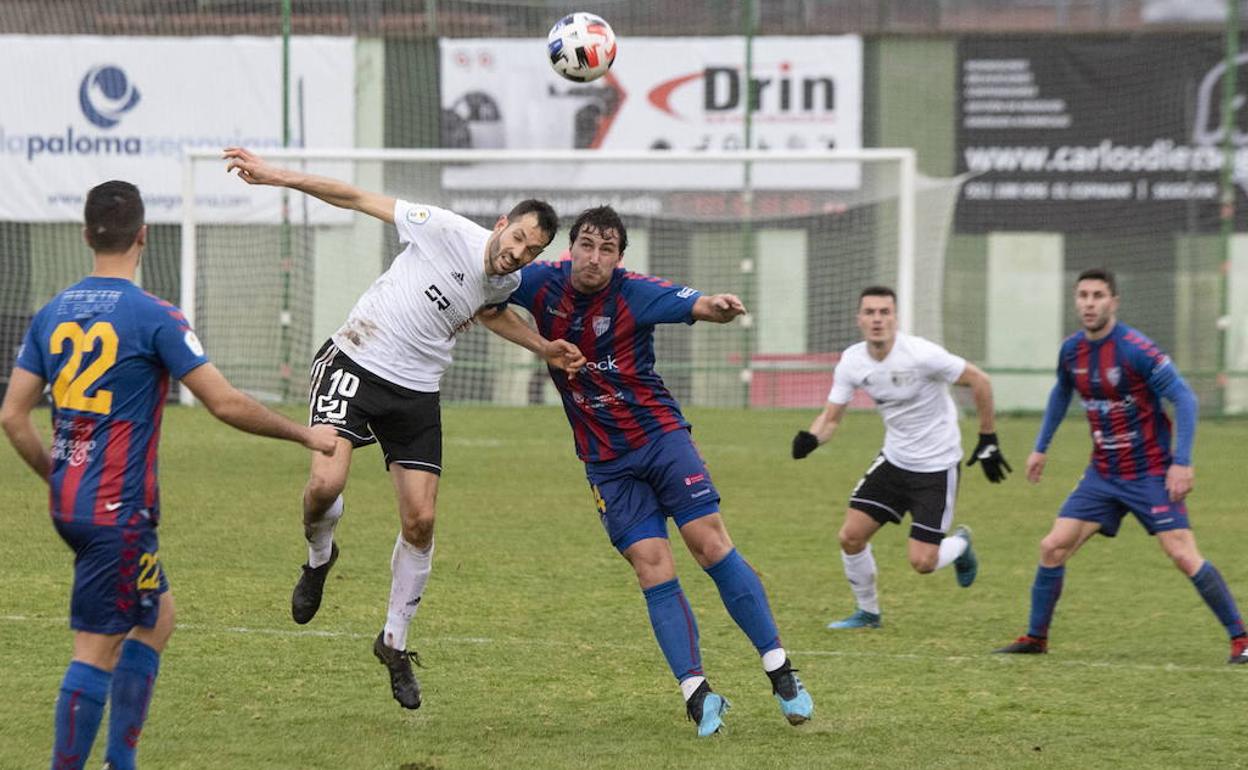 Gabri, del Burgos Promesas, lucha por un balón con un jugador de la Segoviana.