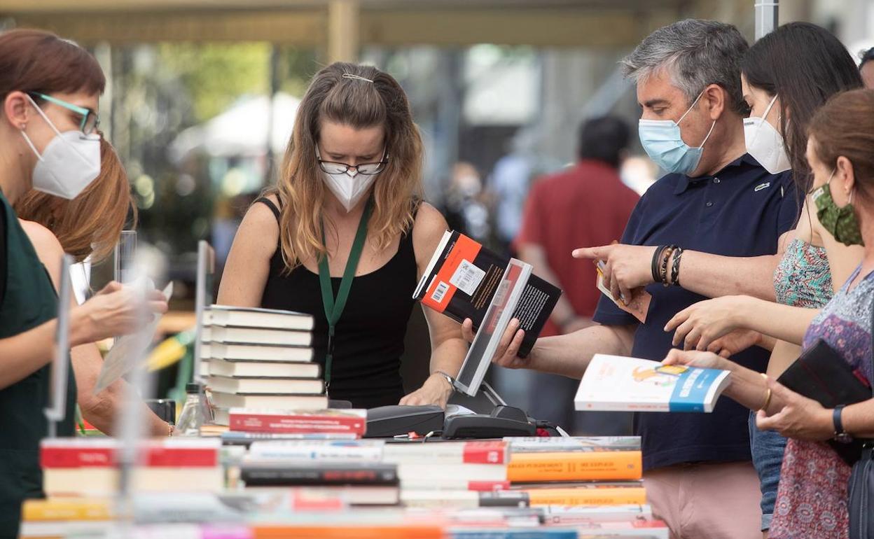 Lectores curioseando un puesto de libros en un Sant Jordi atípico, que en 2020 se celebró el 23 de julio. 