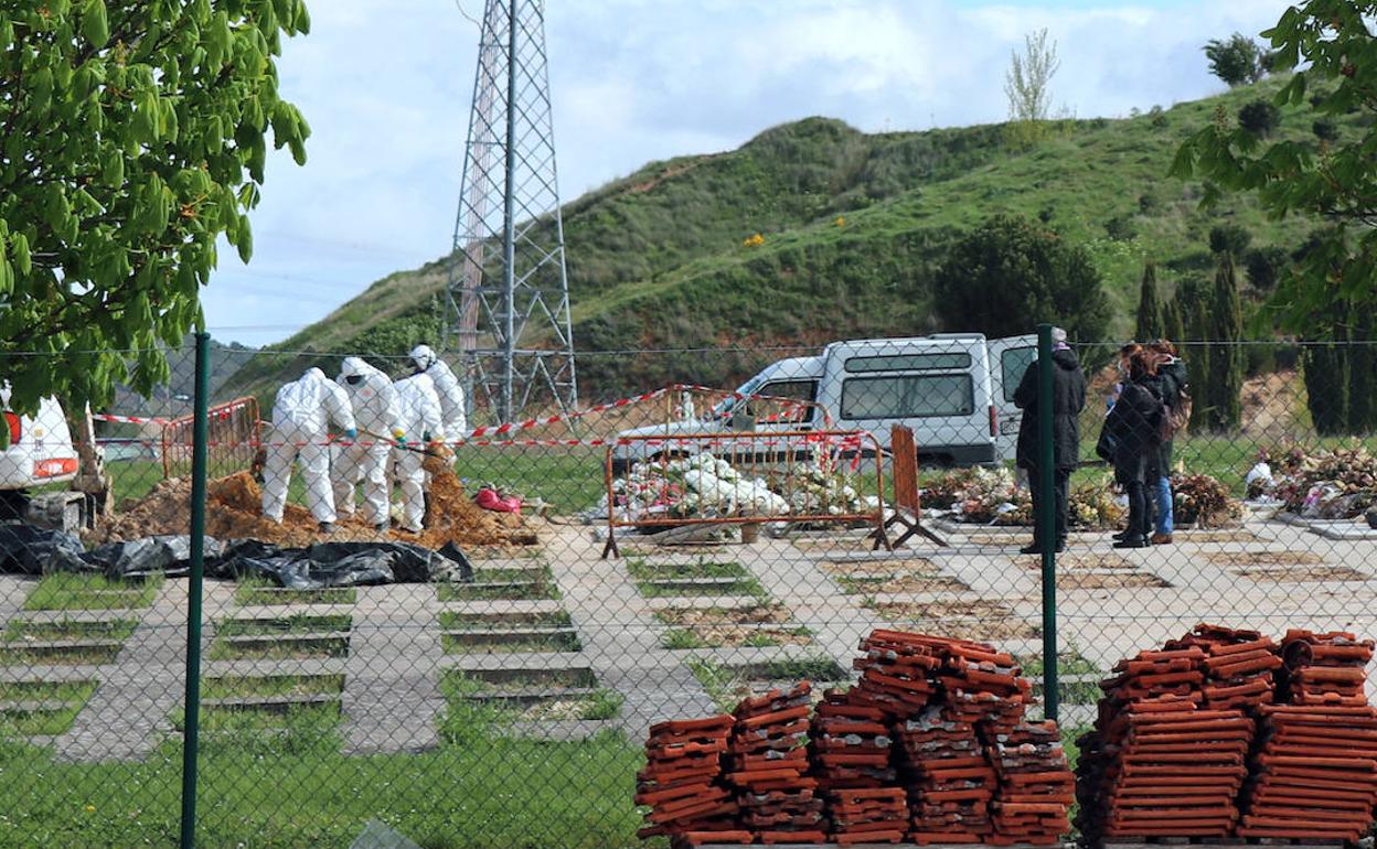 Operarios del cementerio de Burgos entierran a un fallecido por covid-19 durante las restricciones de aforo más fuertes de la pandemia. 