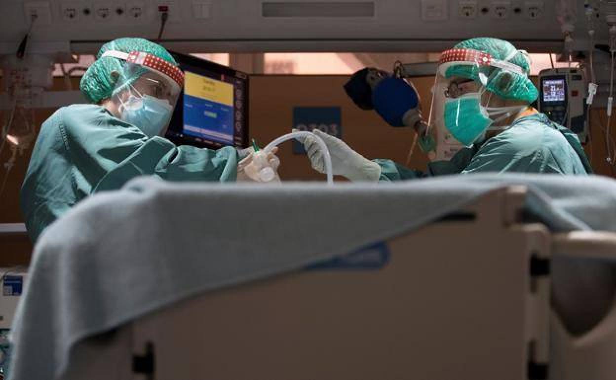 Sanitarios atendiendo a un paciente en la UCI.