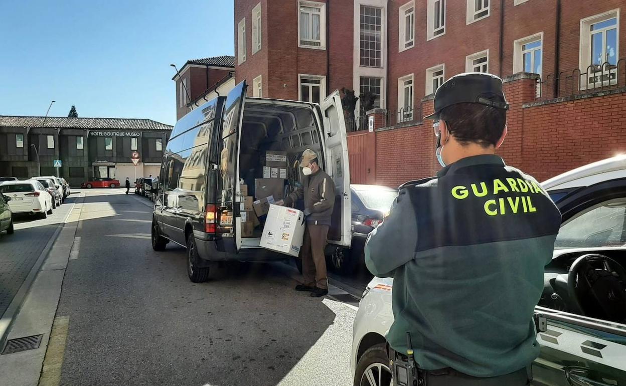 Un guardia civil vigila mientras un operario descarga las vacunas en Burgos.