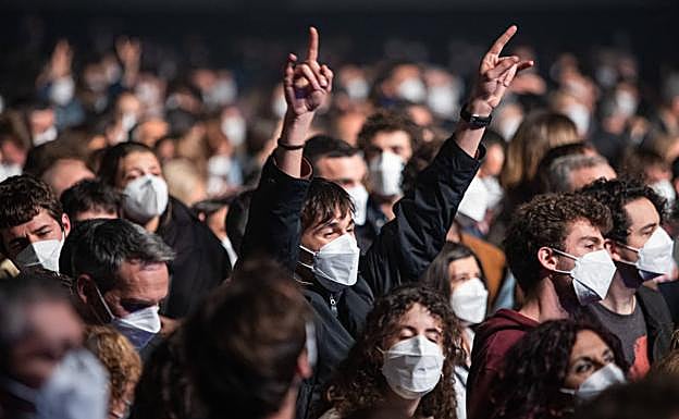 Un joven alza los brazos en el concierto de Love of Lesbian sin distancias, con mascarillas y previo test de antígenos.