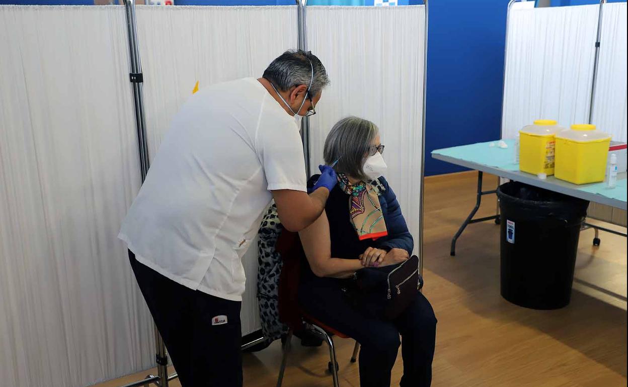 Un enfermero vacuna a una mujer en el Coliseum. 