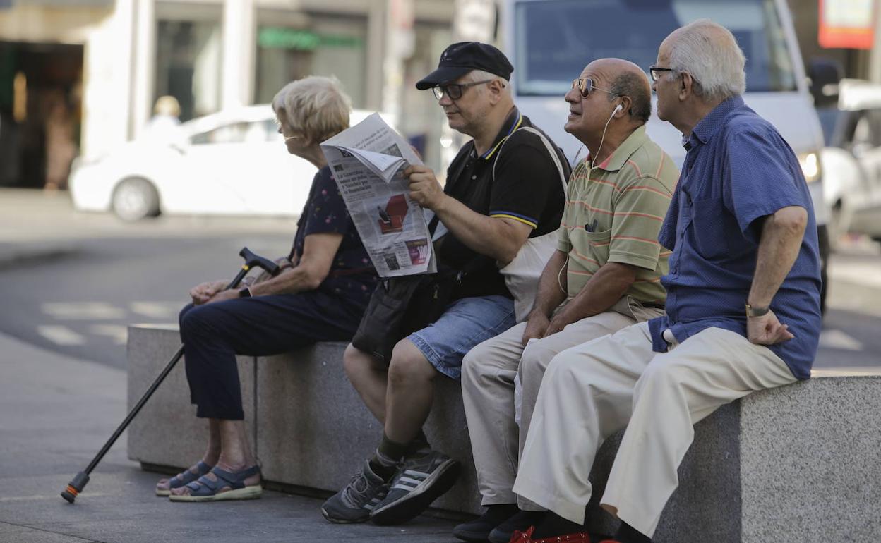 Varios pensionistas sentados en una calle.