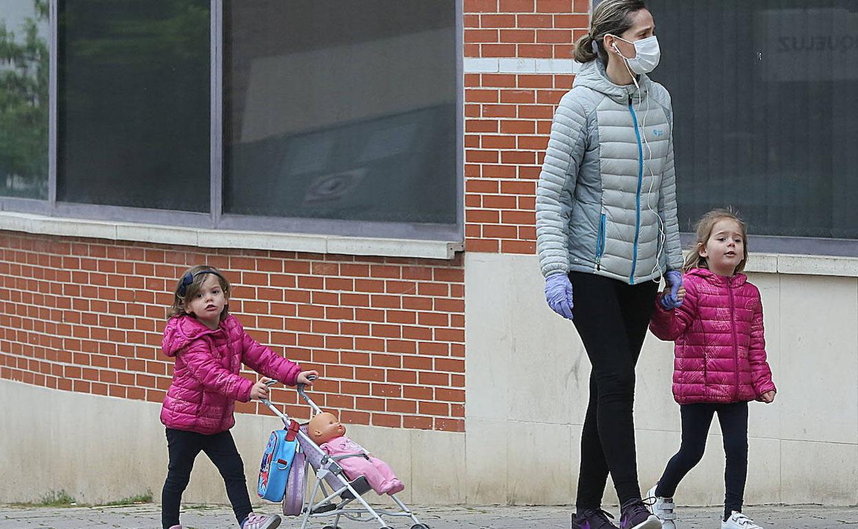 Una madre pasea con sus hijas. 